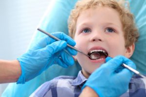 Imagem de criança no dentista sendo examinada