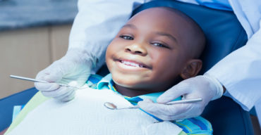 Odontologia pediátrica: na imagem se vê uma criança sorrindo na cadeira do odontopediatra