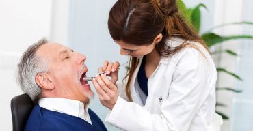 homem idoso com câncer de boca em uma visita ao dentista