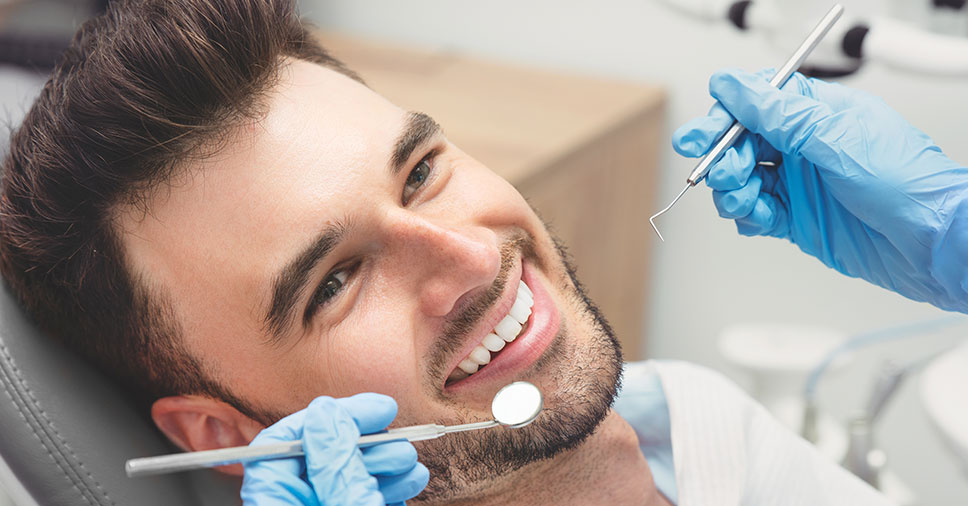 Vemos um homem no dentista. Saiba quais são suas opções para cuidar da estética bucal!